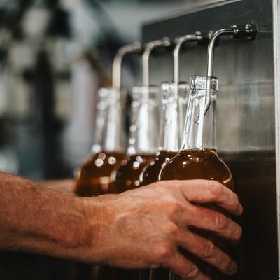 Hands pouring drinks from the dispensary.