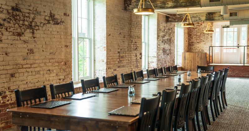 Inside, long wooden table with black chairs