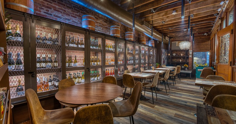 Interior, dining area, wooden top tables for four and two people, large wine cabinets