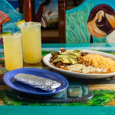 Steak pieces with rice, beans, veggies, burrito wrapped in tin foil, and Margarita cocktail.