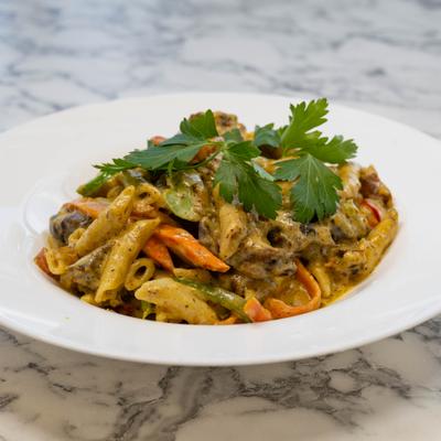 Jerk Chicken Pasta garnished with fresh herbs.