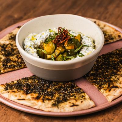 A bowl of Labneh served with flatbread..