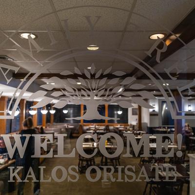 A window overlooking the dining room, featuring the restaurant's logo.