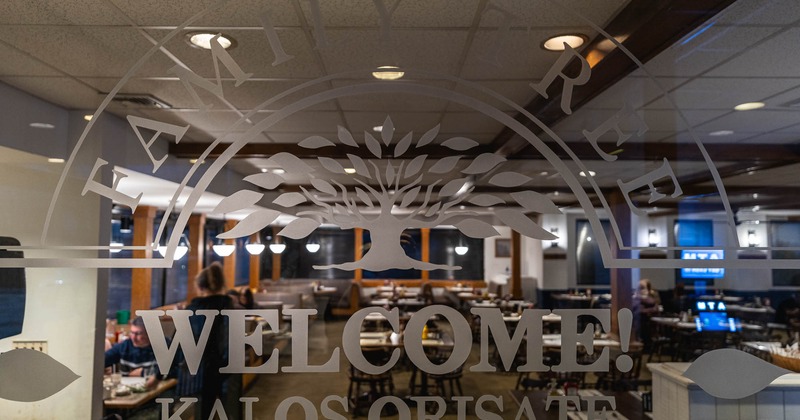 A window overlooking the dining room, featuring the restaurant's logo