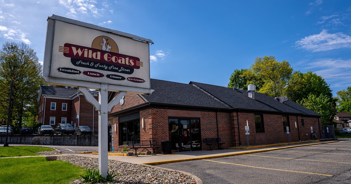 Brick building exterior with a parking lot and outdoor signage