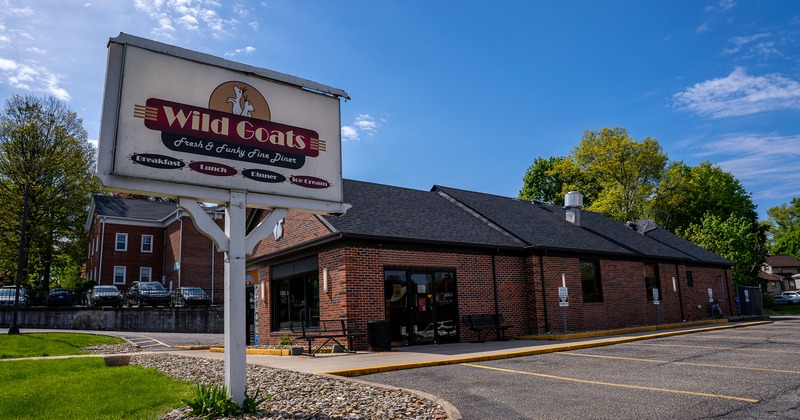 Brick building exterior with a parking lot and outdoor signage