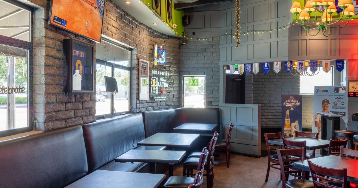 Interior of a casual dining restaurant featuring tables, chairs, and a large TV