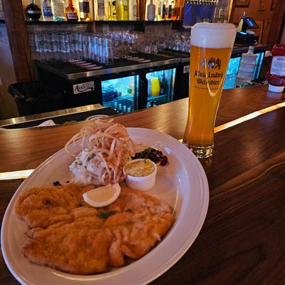 A meal and a large beer served on the bar counter.