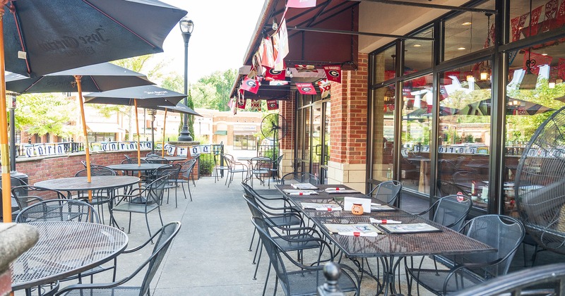 Outdoor seating area with tables, chairs, and black parasols