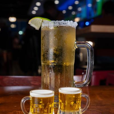Beer, two mini shots and a mug on a bar counter.