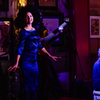 Singer on stage during live entertainment, artwork in view.