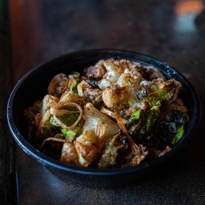 Bowl of roasted cauliflower and brussels sprouts with caramelized onions.