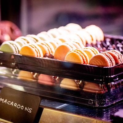 A tray of colorful macarons in a bakery display.