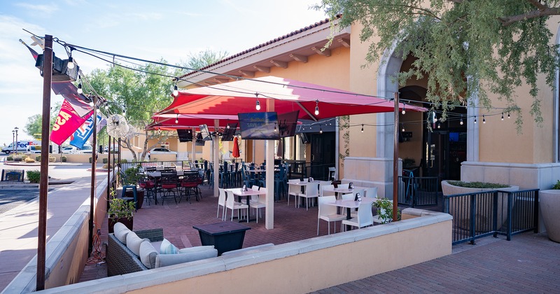 Exterior, patio with tables, chairs and red red parasols