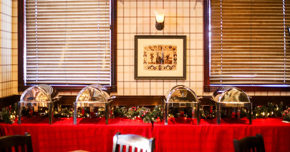 Buffet setup with stainless steel chafing dishes on a red tablecloth