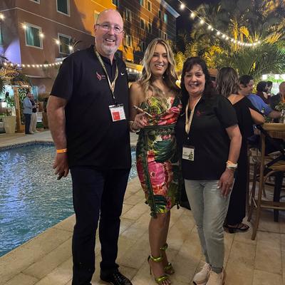 The owner with his spouse and Raquel Quesada at an event.