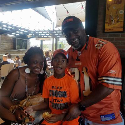 A smiling family in orange jerseys posing for a photo