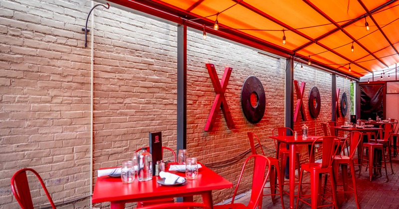 Outdoor dining area with red tables and chairs