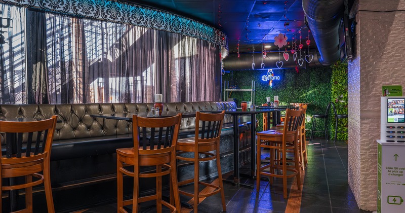 Cozy interior seating area with upholstered seating, high tables, and high stools