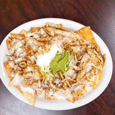 Nachos, with grilled chicken, cheese sauce, sour cream, and guacamole.