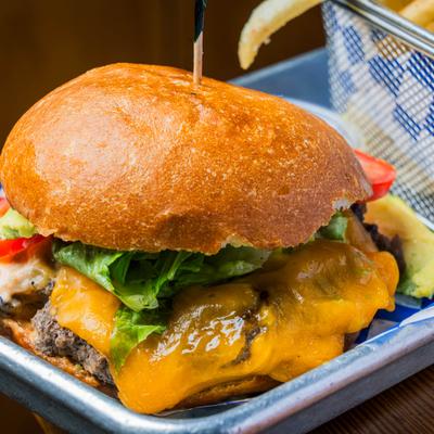 Cheeseburger with lettuce beside crispy fries.