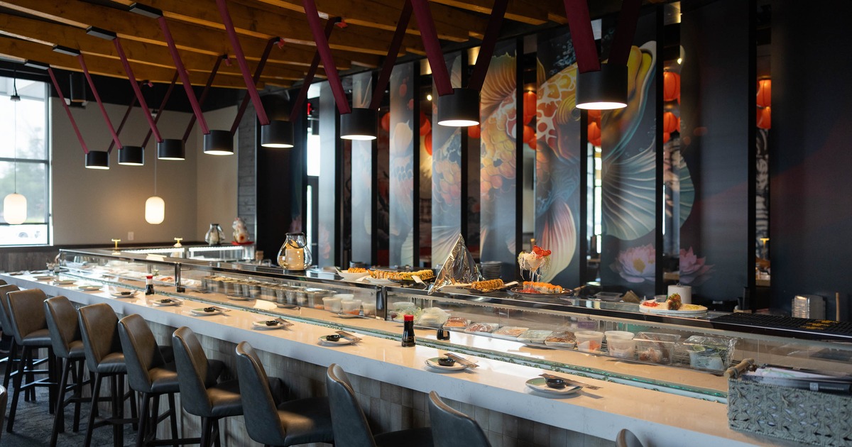 Modern sushi bar with a long counter adorned with plates of sushi