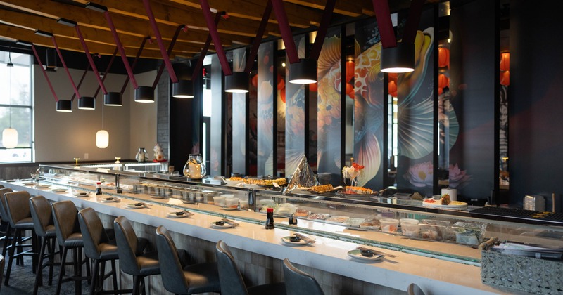 Modern sushi bar with a long counter adorned with plates of sushi