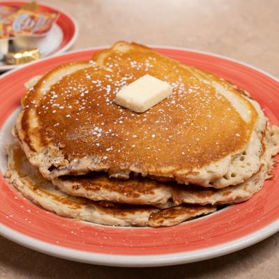 Stack of pancakes with butter and syrup.