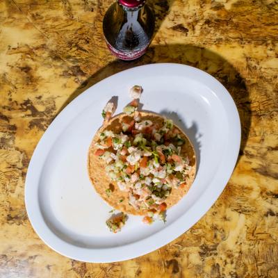 Overhead view of a plate with Shrimp Ceviche  and a bottle of soda drink.