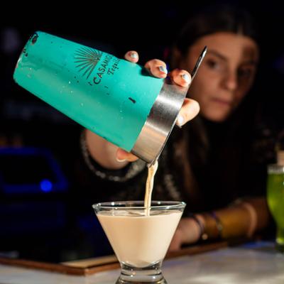 Bartender pouring a cocktail.