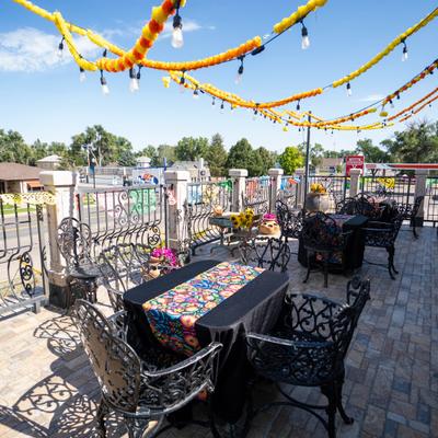 Fenced patio decorated with yellow marigold garlands and string lights.