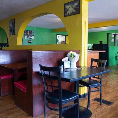 Interior with yellow walls contrasted with green accents and wooden booths.