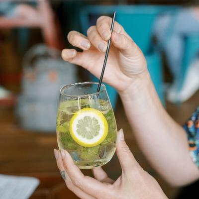 Woman mixing a cocktail, side view.