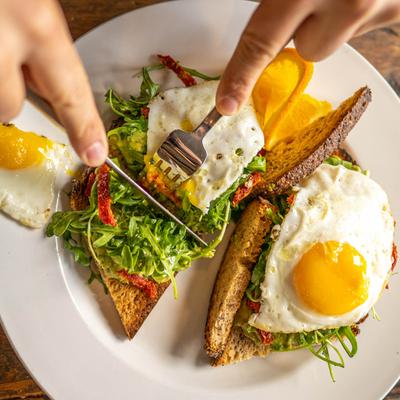 Cutting Avocado Toast on the plate, overhead view