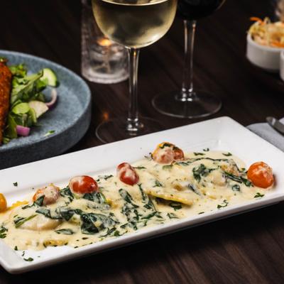 Lobster Ravioli topped with sauce, cherry tomato and fresh herbs.