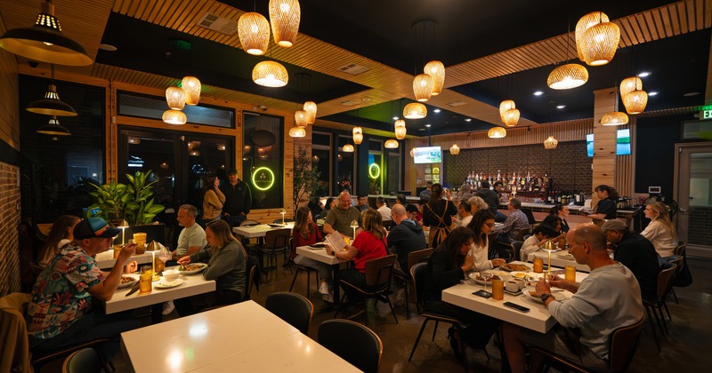Interior, dining space with white tables and chandeliers