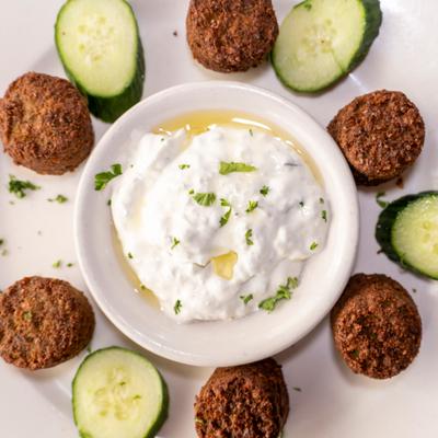 Falafel served with tzatziki dip and sliced cucumbers.