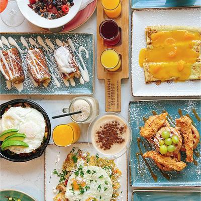 A variety of dishes and drinks spread on a table, overhead view.
