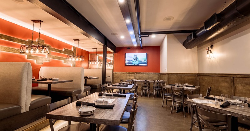 Interior, wide view of dining area, TV screen on the wall