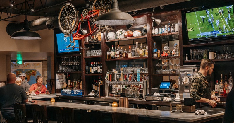 Bar, chairs, stools shelf with drinks behind
