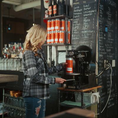 Employee sealing beer cans.