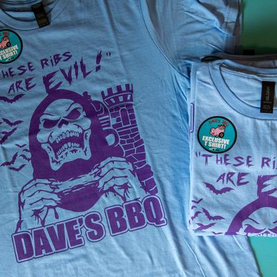 Light blue t shirts with a Skeletor print and the text These ribs are evil, Dave's BBQ.
