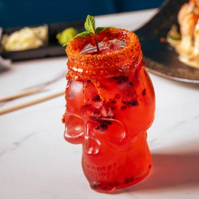 Cocktail served in a chili-rimmed, skull-shaped glass.
