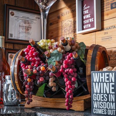 Wine cork display surrounded by colorful grapes.