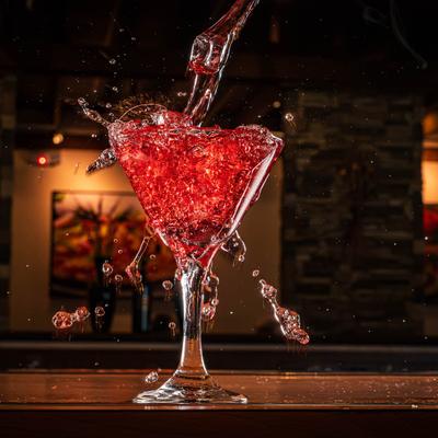 A martini glass with red sangria splashing out.