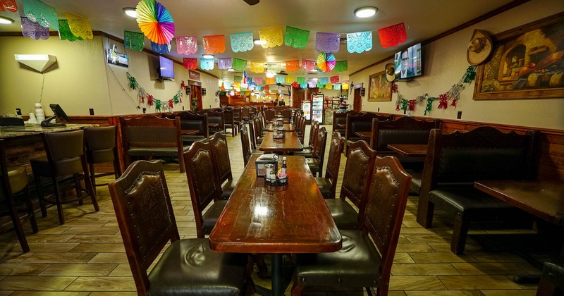 Interior with wooden tables and colorful decorations hanging from the ceiling