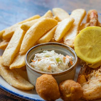 Fried shrimp and crab bites served with steak fries, coleslaw, and lemon half.
