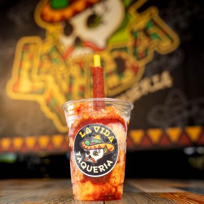 Frozen drink served in a branded plastic cup with a tamarind candy straw.