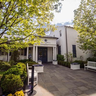 Exterior with benches, trees, plants, and  a partial view of signage.
