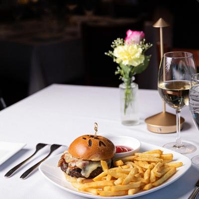 Wagyu Truffle Burger served with fries, dipping sauce and a glass of wine.